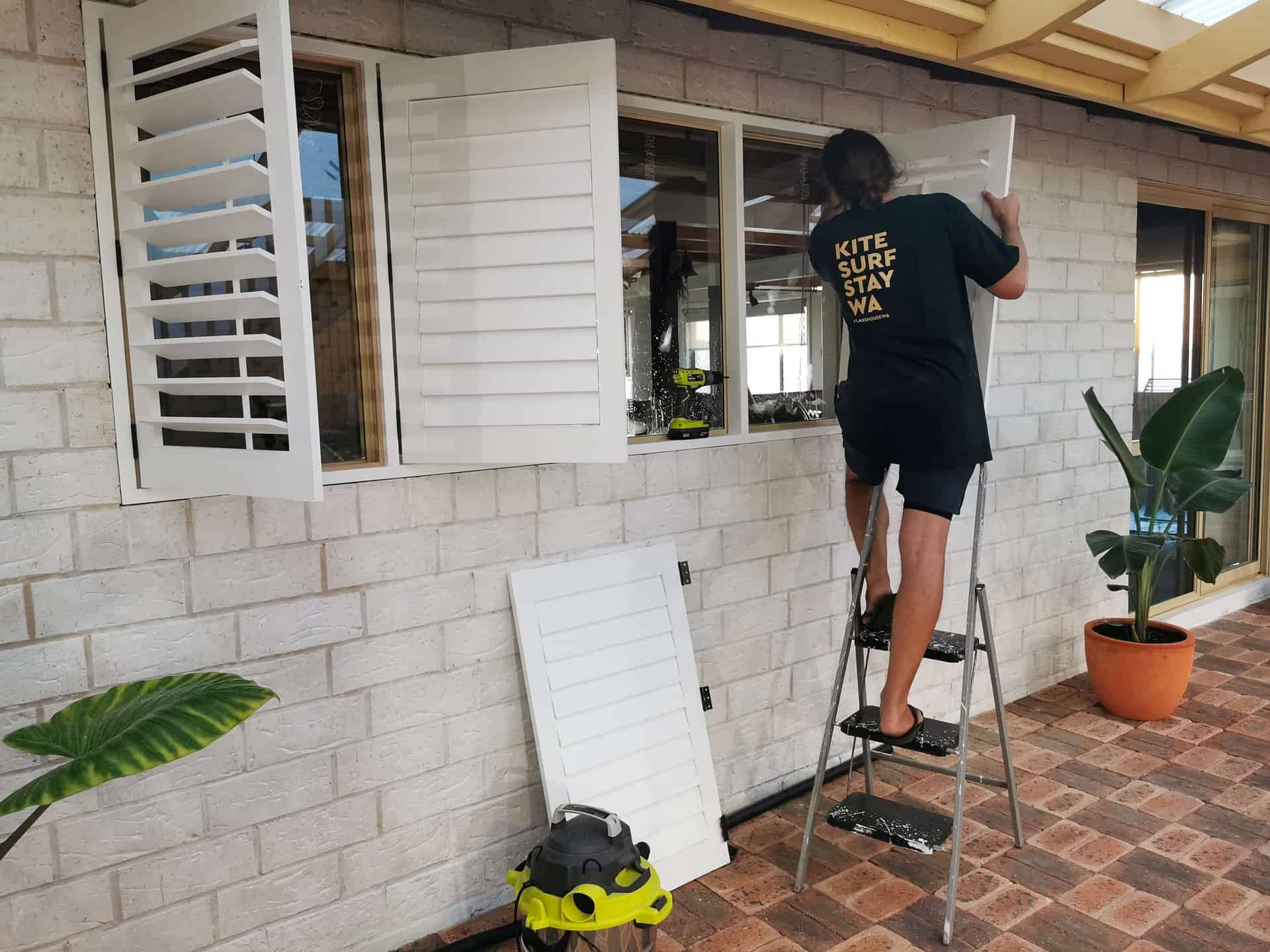 Installing plantation shutters in the courtyard at The Glass House in Greenough, Western Australia