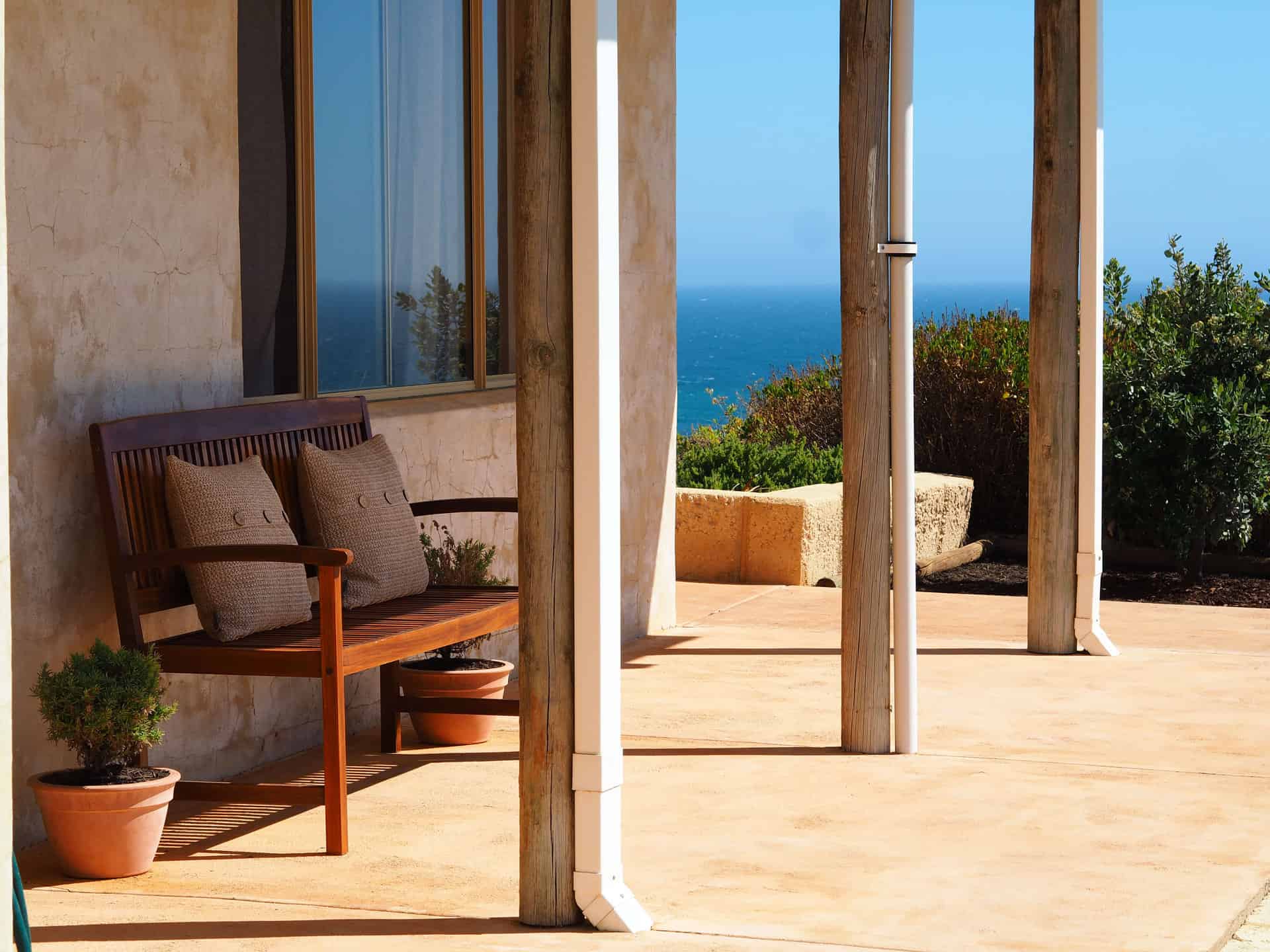 an outdoor bench with a view of the Indian Ocean