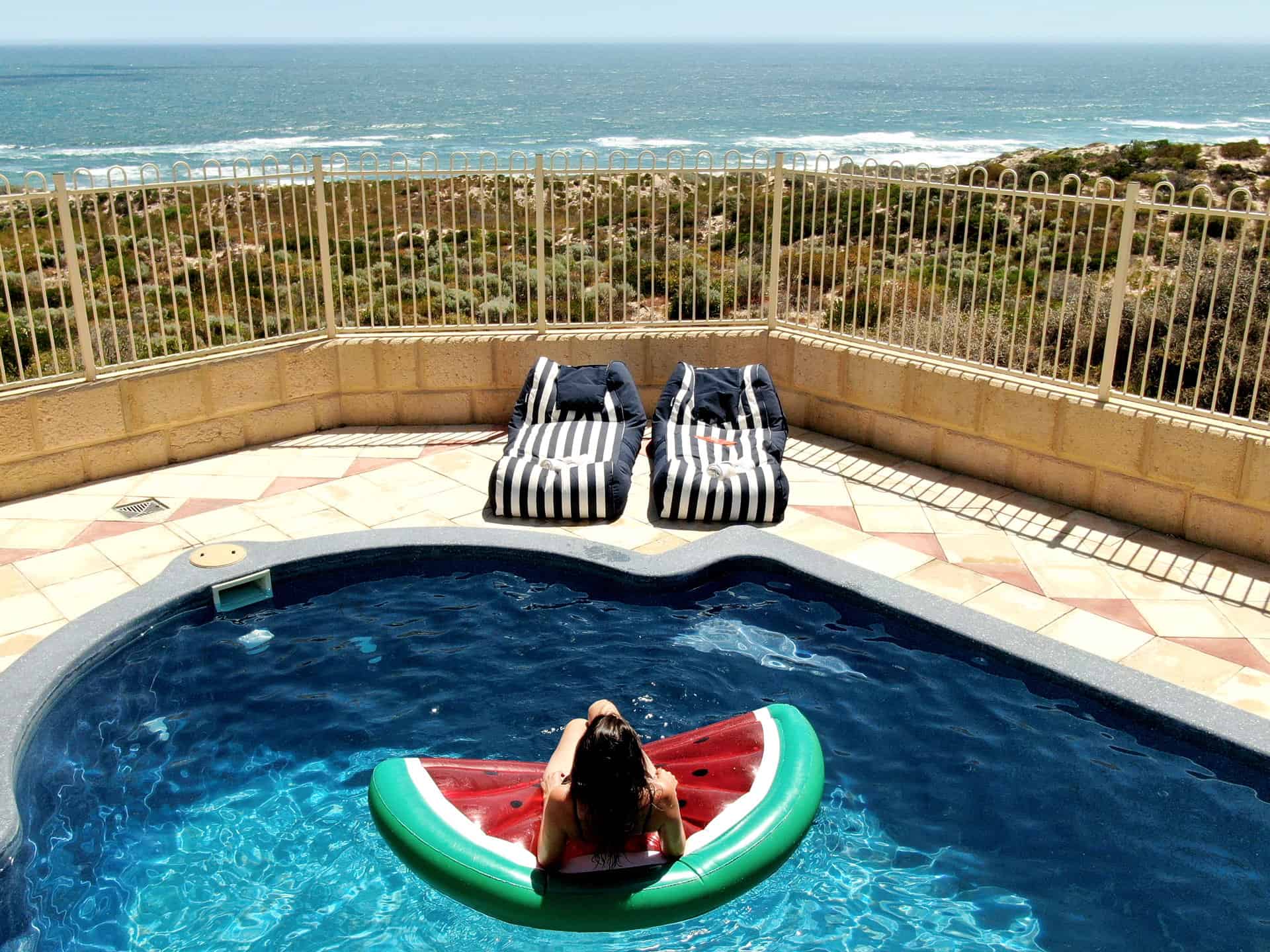 In the pool on a watermelon lilo overlooking the beach in Greenough, Western Australia